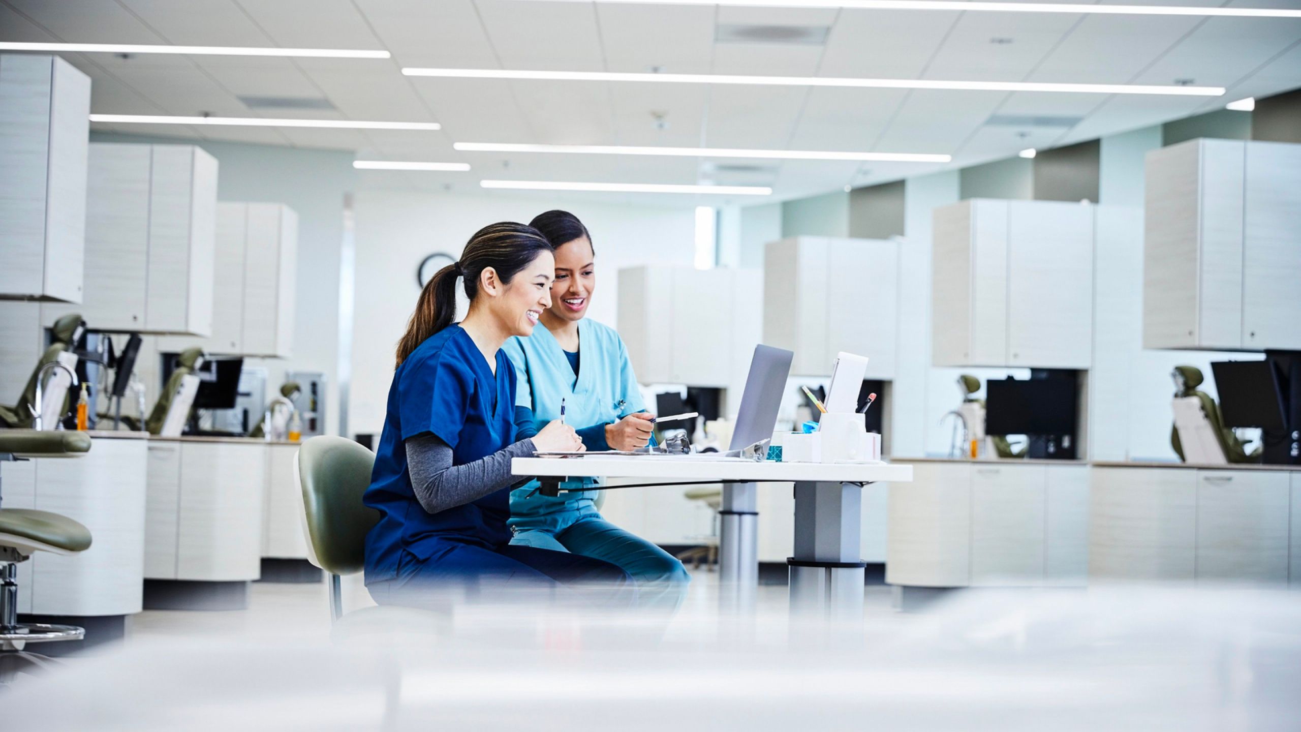 Two women working on their laptops in a lab